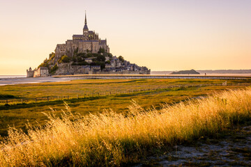 The Mont Saint-Michel tidal island at sunset in Normandy, France.
