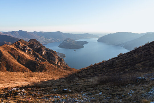 View of Lake Iseo at sunset, with the alps framing it, near the town of Zone, Italy - February 2022.