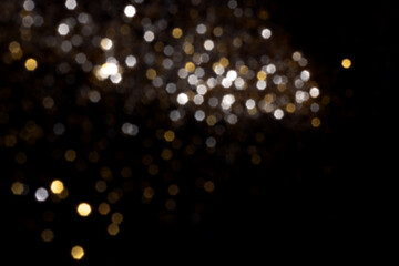 Golden and silver blurred bokeh lights on black background. Glitter sparkle stars for celebrate....