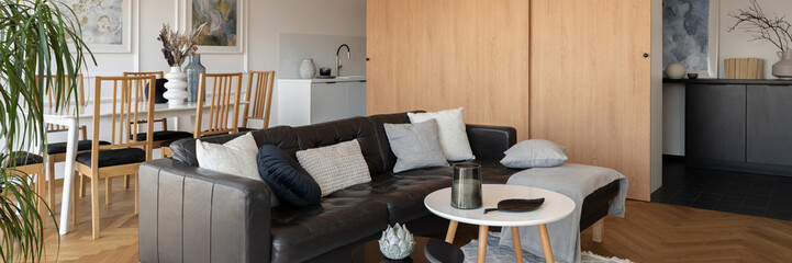 Black corner sofa in open living room, panorama