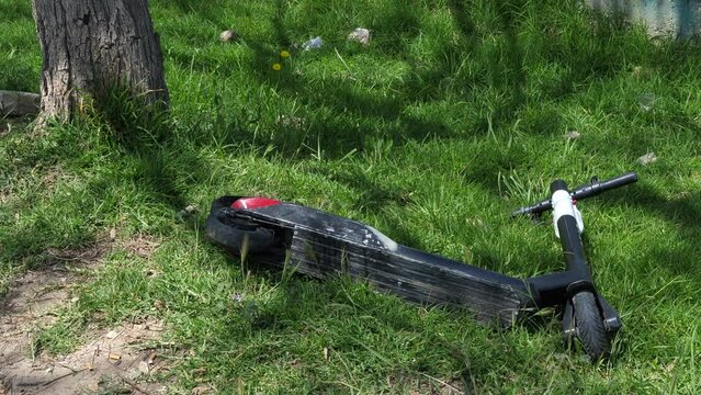 Close up of electric scooter fallen on roadside. Static, high angle