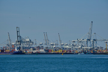 ROTTERDAM, THE NETHERLANDS - New container terminal with a very large container ship and in the foreground a smaller inland container ship on the Maasvlakte of the port of Rotterdam