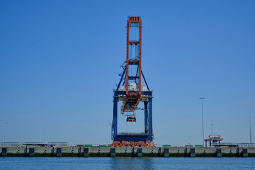 Fototapeta na wymiar ROTTERDAM, THE NETHERLANDS - New container terminal with a very large container ship and in the foreground a smaller inland container ship on the Maasvlakte of the port of Rotterdam