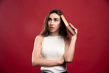 Photo of beautiful lady holding a book on a red background