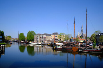 Fototapeta na wymiar GOUDA, NETHERLANDS - Panorama of historic ships and lock in the harbor of Gouda, Netherlands