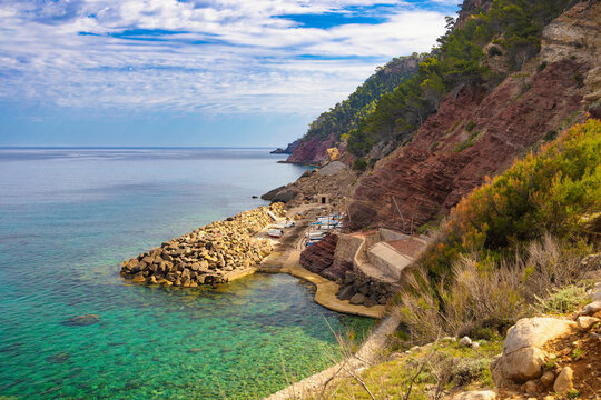 Sheltered by a stone breakwater and cliffs is a small fishing port in Cala Estellencs, Majorca, Spain
