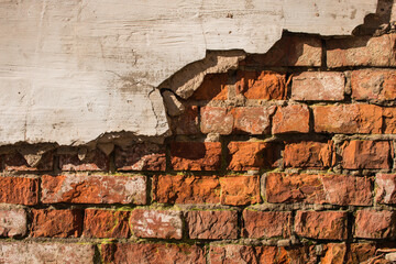 fallen off plaster on a brick wall background