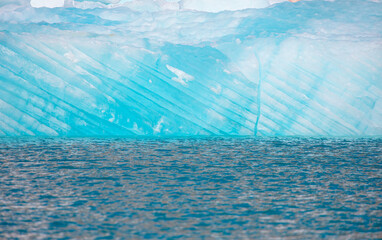 Melting icebergs by the coast of Greenland, on a beautiful summer day - Melting of a iceberg and pouring water into the sea - Greenland