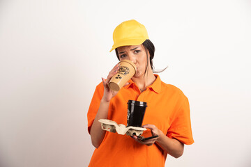 Woman in uniform drinking from one cup of coffee