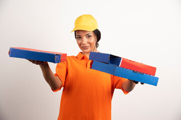 Happy delivery woman holding pizza boxes on white background