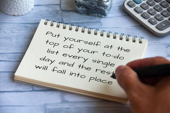 Life inspirational quote - Put yourself at the top of your to-do list every single day and the rest will fall into place. Hand writing on notepad