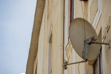 Back view of a satellite dish antenna installed on the exterior wall of a construction