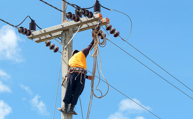 Electrician lineman repairman worker at climbing work on electric post power pole