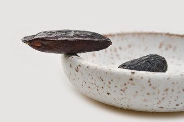 Fragrant tonka beans for baking and cooking on white background. Bean of Dipteryx odorata, cumaru...