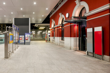 Detail of the newly renovated Lugano railway station. The building is red, on the left there are...