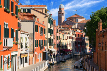Fototapeta na wymiar Scenic cityscape of Venice city with beautiful old architecture and with water streets of the Grand Canal with moored boats against the blue sky on a sunny day. Venice, ITALY