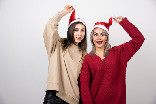 Image of a happy women holding a Santa hats