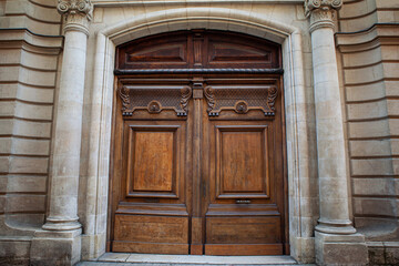 Elegant wooden door on a facade in French Bordeaux city
