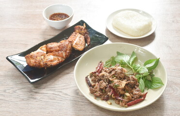 Thai spicy slice beef salad eat couple fresh basil and grilled slice chicken wing on plate