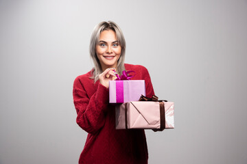 Portrait of happy woman with gift boxes posing