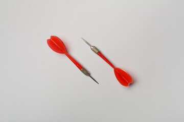 Red darts on color background, top view