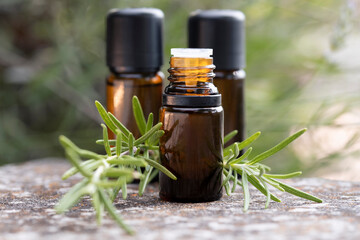 Close-up of three brown bottles with natural rosemary essential oil