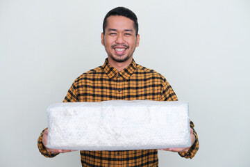Adult Asian man smiling while giving big wrapped package
