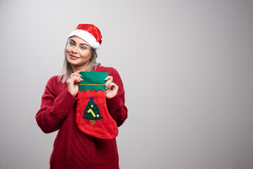 Woman in red outfit showing Christmas stocking