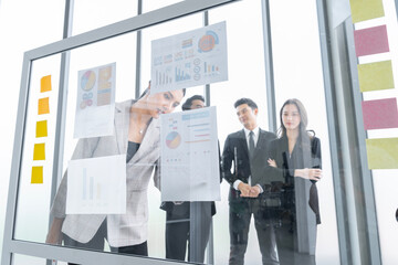 A group of Asian businessmen are gathering ideas to share ideas and offer ideas at a board in the office. with determination, determination and good fun