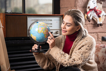 Portrait of beautiful lady pointing at a world globe