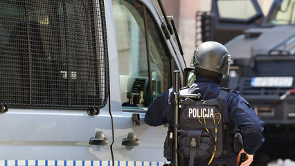 Policjant w niebieskim mundurze uzbrojony w pistolet maszynowy w czasie ćwiczeń. 