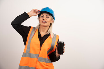 Construction worker posing with cup of tea on white background
