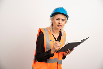 Woman construction worker writing in notebook