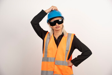 Young woman builder posing with goggles and helmet
