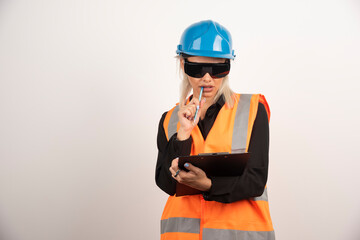 Woman builder with goggles holding clipboard