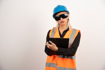 Woman builder with goggles holding clipboard