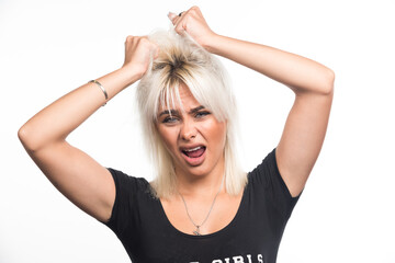 Fototapeta premium Young woman pulling out her hair on white background