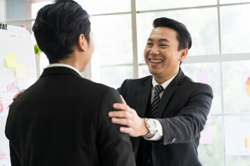 Asian business man shaking hands together after finishing up meeting in the office. Investment deal, Partnership concept.