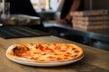 Freshly baked pepperoni pizza at a pizzeria restaurant. Pizzeria.