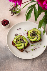 Sandwiches with boiled beetroot and avocado with microgreens, delicious healthy breakfast