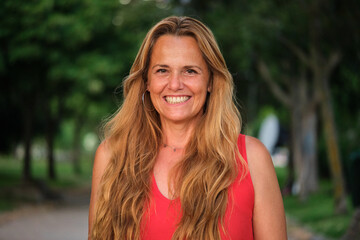 Outdoor portrait of smiling mature blonde woman. Middle aged woman.