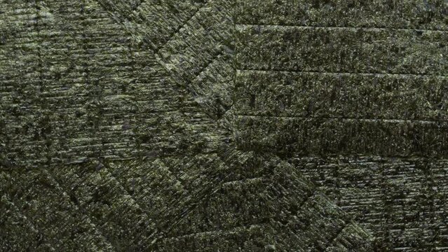 Dry nori seaweed sheets background. Asian cuisine ingredient. Table spin.