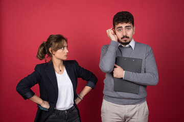 Young woman looking at man with clipboard angrily