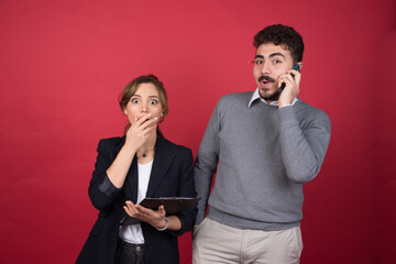 Happy man speaking on phone and standing near shocked woman