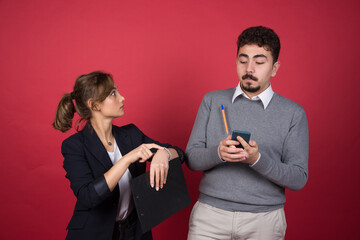 Young man holding a phone and standing near shocked woman