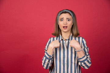 Female teenager in striped shirt pointing at herself