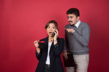 A young woman talking on smartphone near angry boyfriend