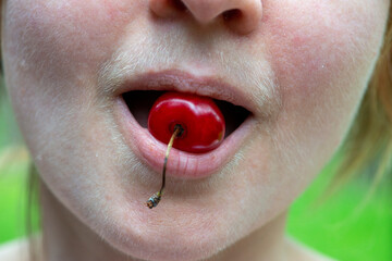 Composition of a sweet cherry and a natural hairy upper lip of a body positive young woman.