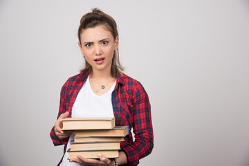 Photo of a young student holding a stack of books