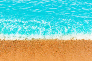 Obraz premium Blue sea wave,golden sand beach,white foam,turquoise ocean water.Close-up.Summer holidays concept.Tropical island vacation backdrop,tourist travel banner design template, copy space.